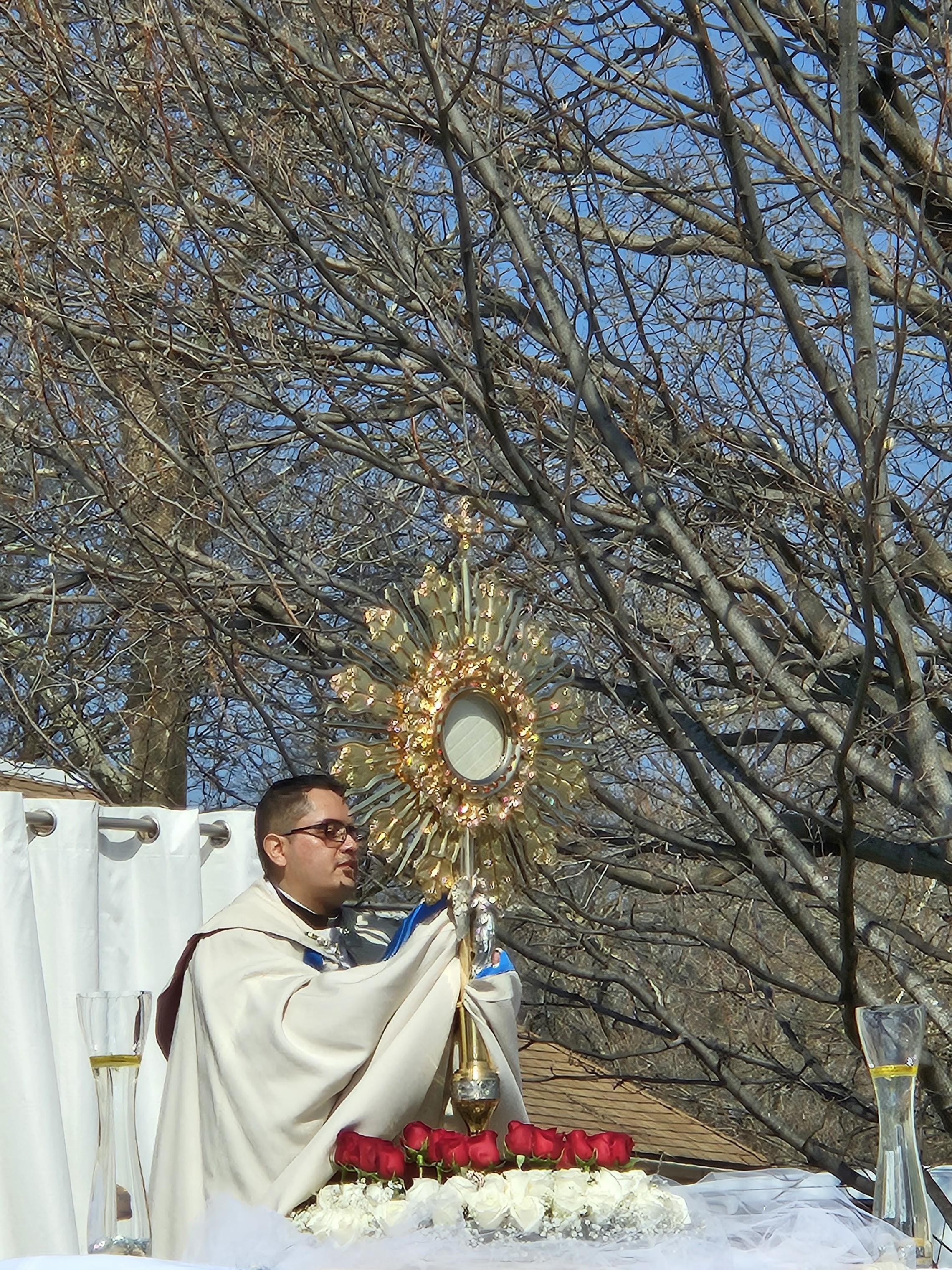 Father Emmanuel gives a benediction following a Eucharistic Procession outside
